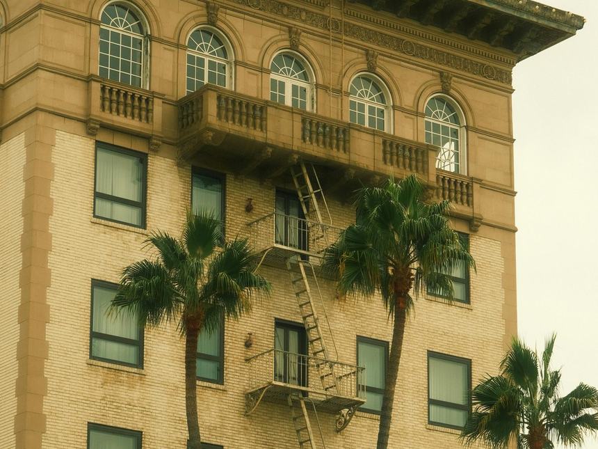 Historic Los Angeles architecture with palms and fire escape, LADWP territory