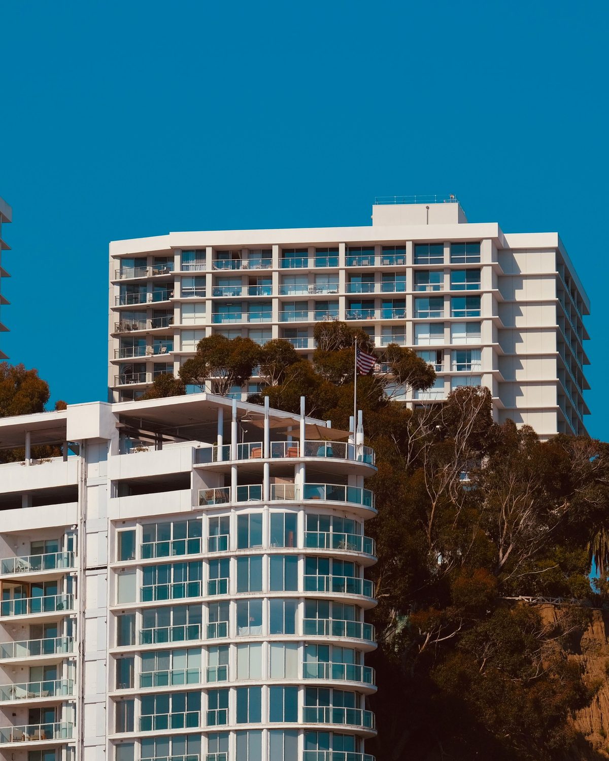 White modernist multifamily high-rise against blue sky — Southern California